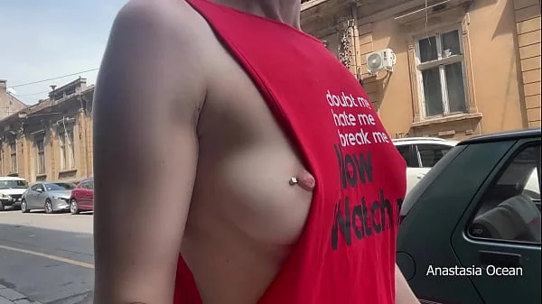 Braless walk in city. Flashing piercing nipples in public.